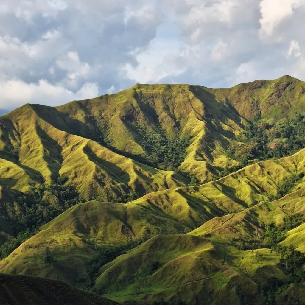 Rolling green grassland of Communal Ranch Bukidnon with Mt. Kulago visible in the distance