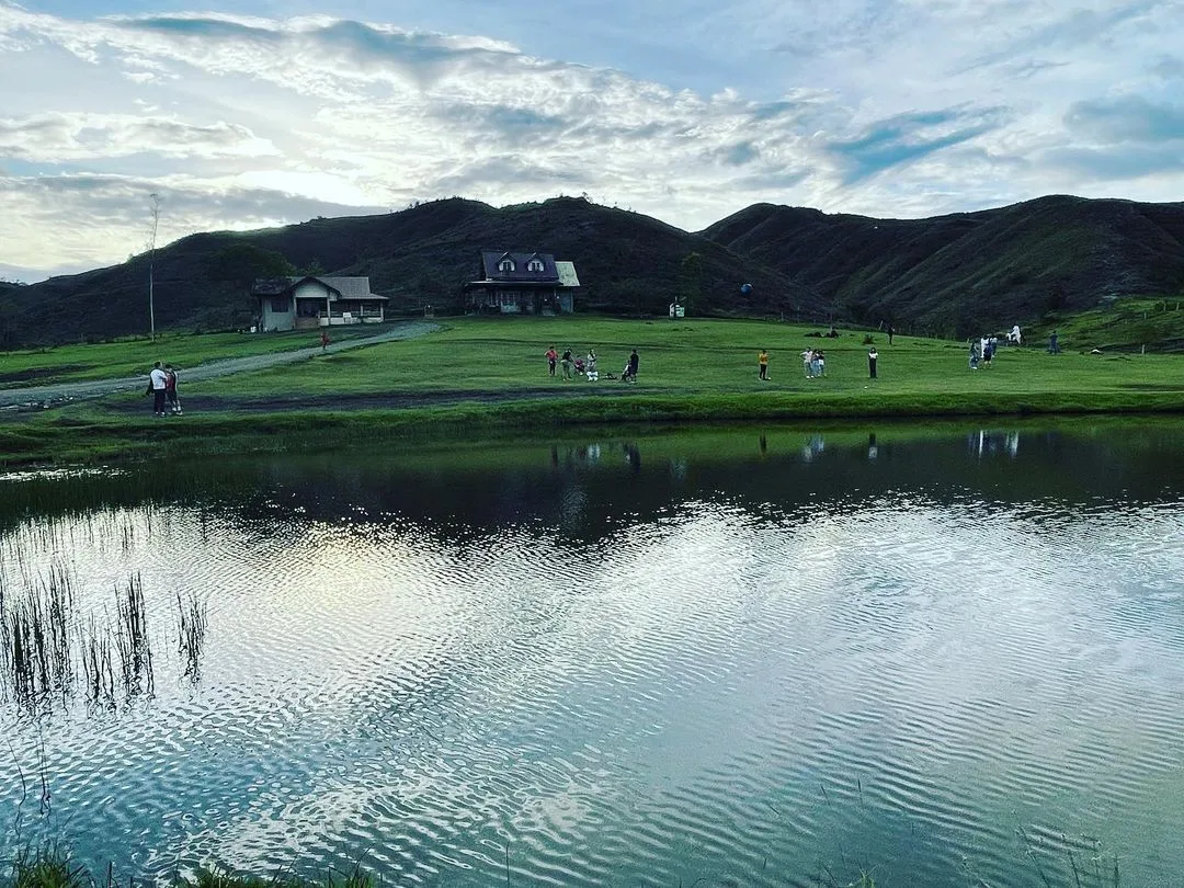 Heart-shaped man-made pond at Communal Ranch Impasugong with mountain backdrop