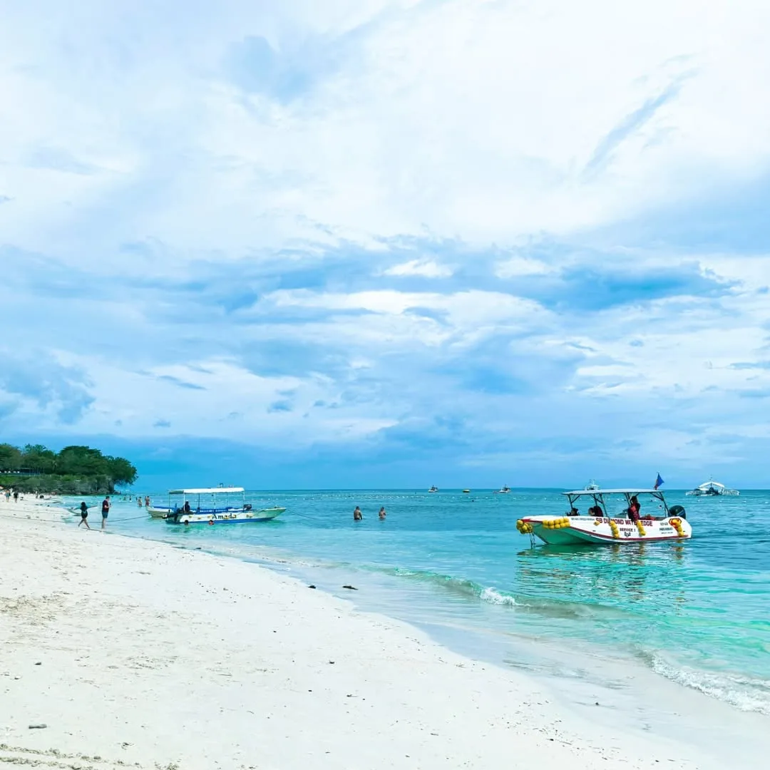 Outrigger bangka boats anchored near Alona Beach ready for island hopping tours to Balicasag reef and Virgin Island sandbar
