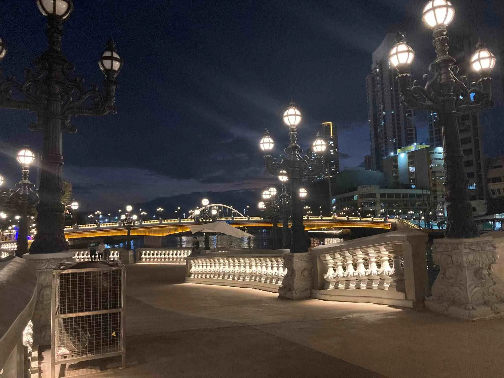 Pasig River Esplanade neoclassical walkway at sunset with Jones Bridge and Post Office ruins in the background