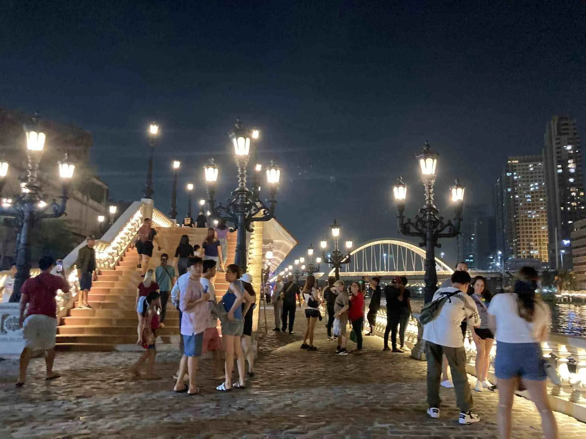 Wide paved esplanade walkway showing separate pedestrian and cyclist lanes under heritage lamp posts