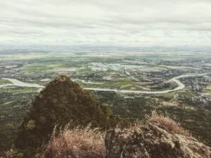 Hiker standing at the North Peak summit of Mt. Arayat in Pampanga, with sweeping 270-degree views of the Central Luzon plains below
