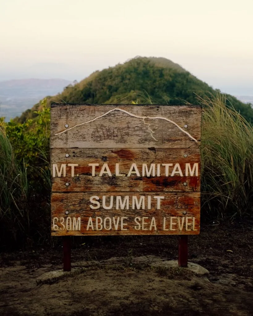 Panoramic summit view from Mt. Talamitam in Nasugbu Batangas showing vast cogon grasslands and distant mountain ridges under a bright sky