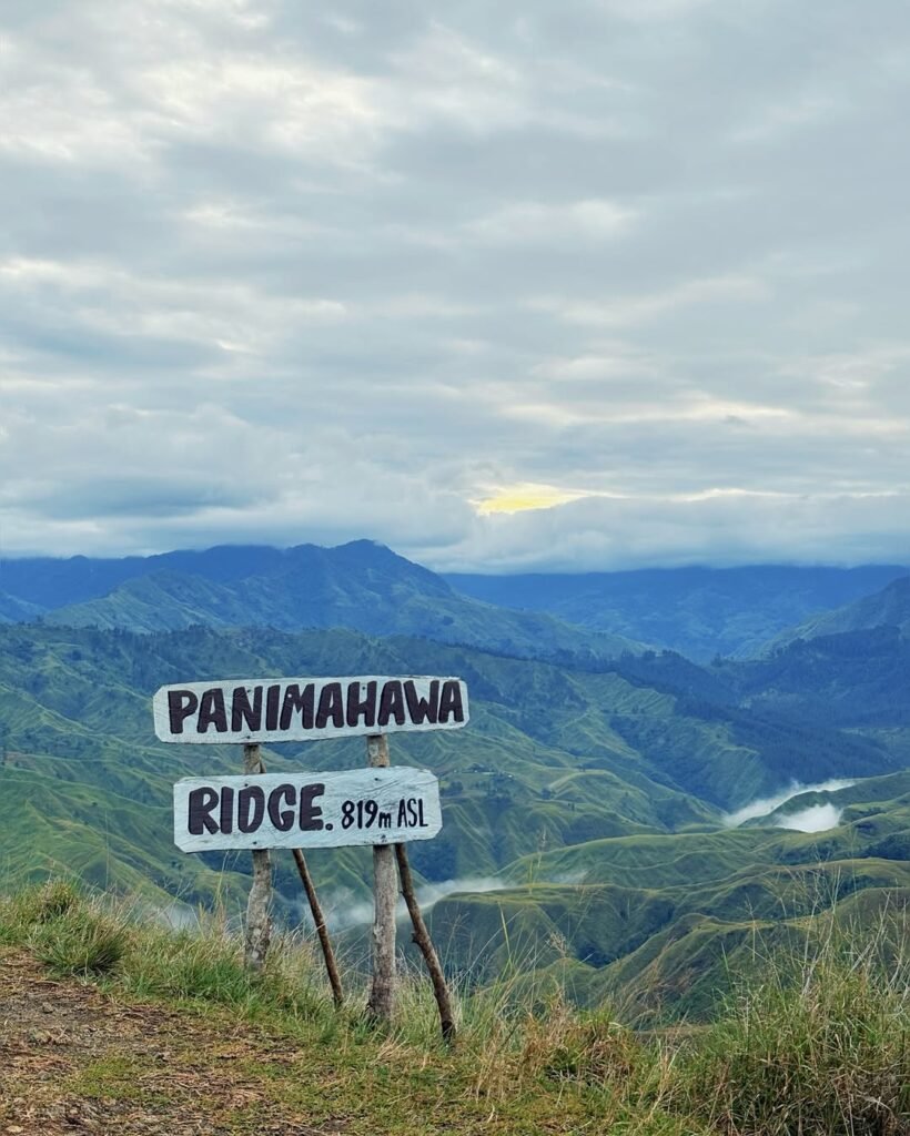Panimahawa Ridge summit sign “819m ASL” overlooking rolling green hills in Impalutao, Impasug-ong, Bukidnon.