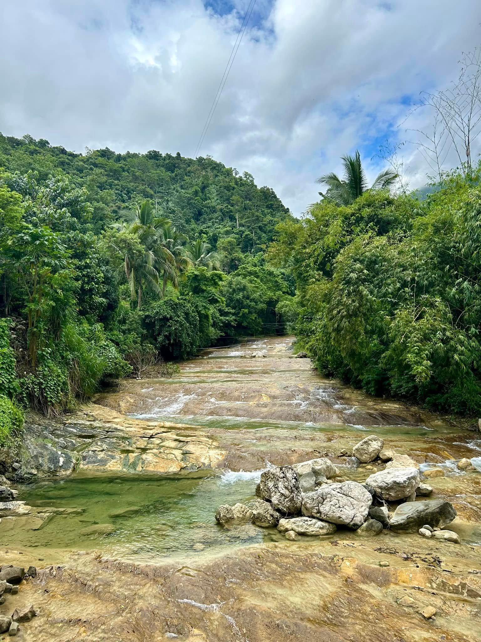Lablabasan River flowing through Barangay Alfonso with clear blue water and forested canyon walls in Gregorio del Pilar, Ilocos Sur