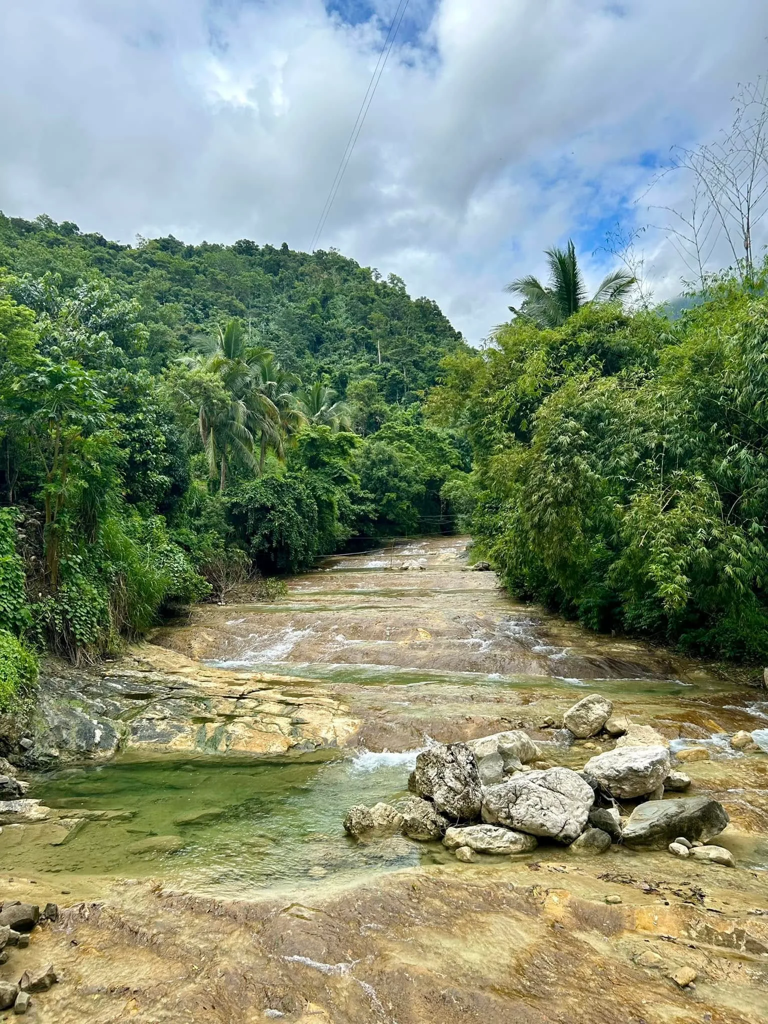 Lablabasan River flowing through Barangay Alfonso with clear blue water and forested canyon walls in Gregorio del Pilar, Ilocos Sur