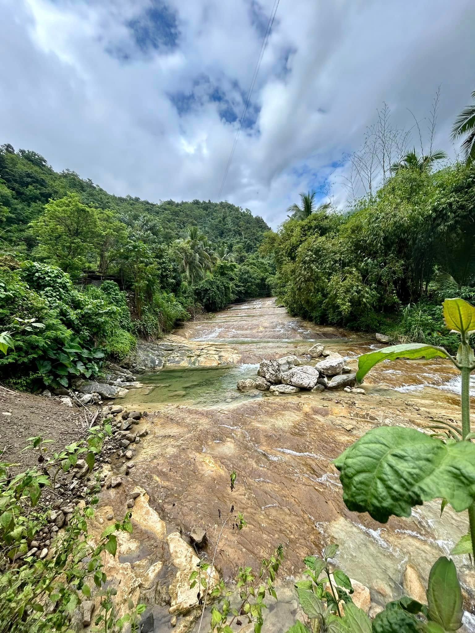 Lablabasan River flowing through Barangay Alfonso with clear blue water and forested canyon walls in Gregorio del Pilar, Ilocos Sur
