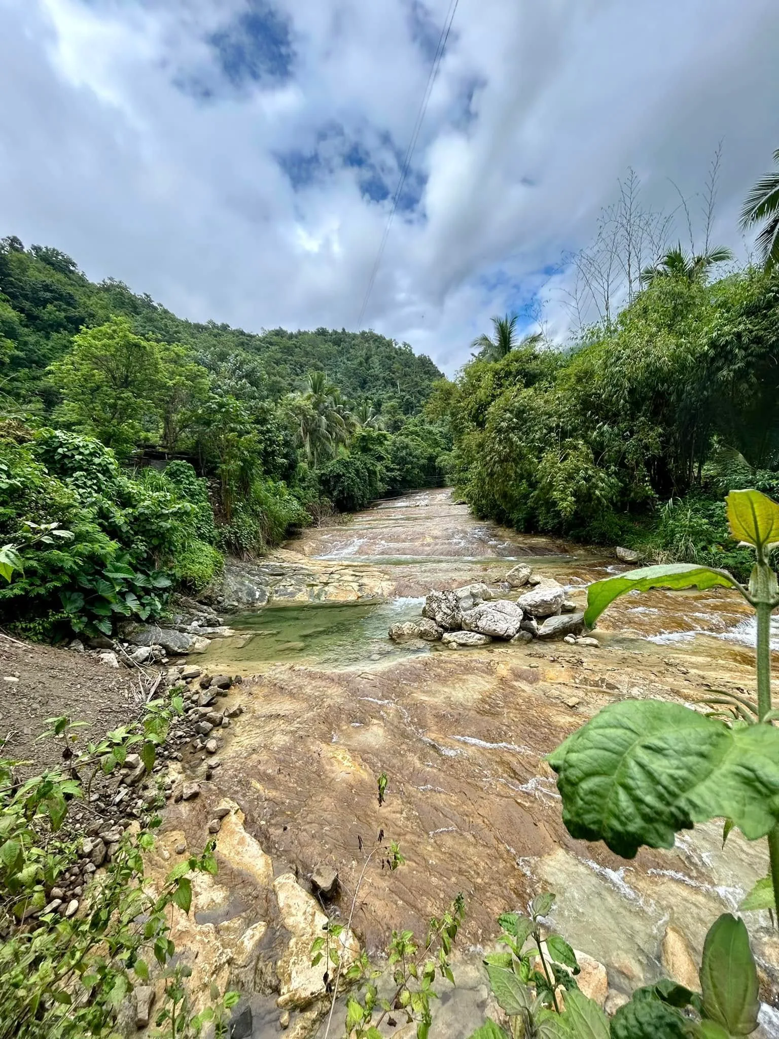 Lablabasan River flowing through Barangay Alfonso with clear blue water and forested canyon walls in Gregorio del Pilar, Ilocos Sur