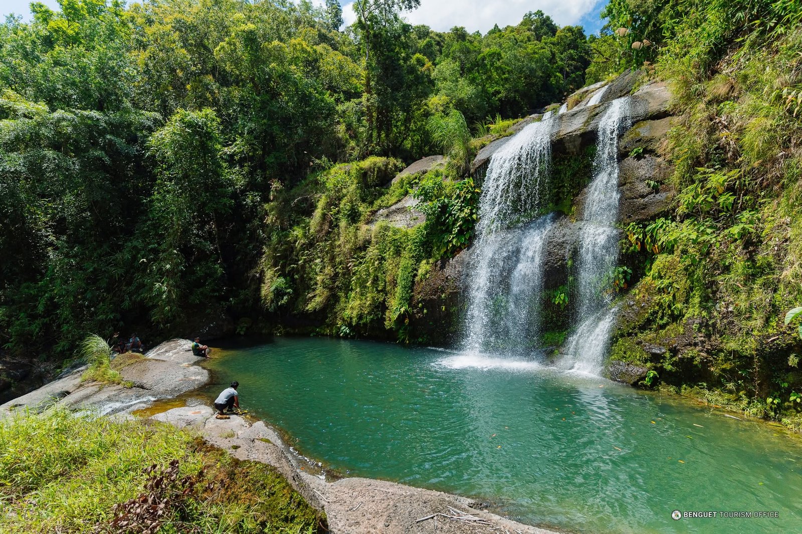 Natural plunge pool at the base of Tulali Falls with mossy boulders and mountain water