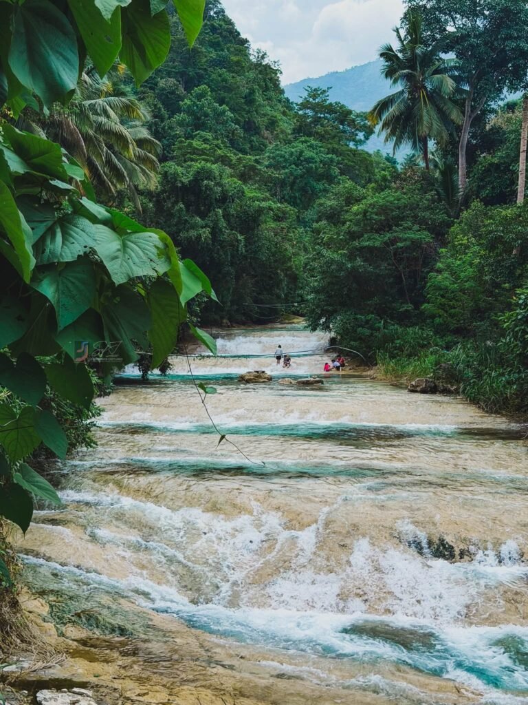 Lablabasan River and Kintukudan Falls flowing through Barangay Alfonso with clear blue water and forested canyon walls in Gregorio del Pilar, Ilocos Sur