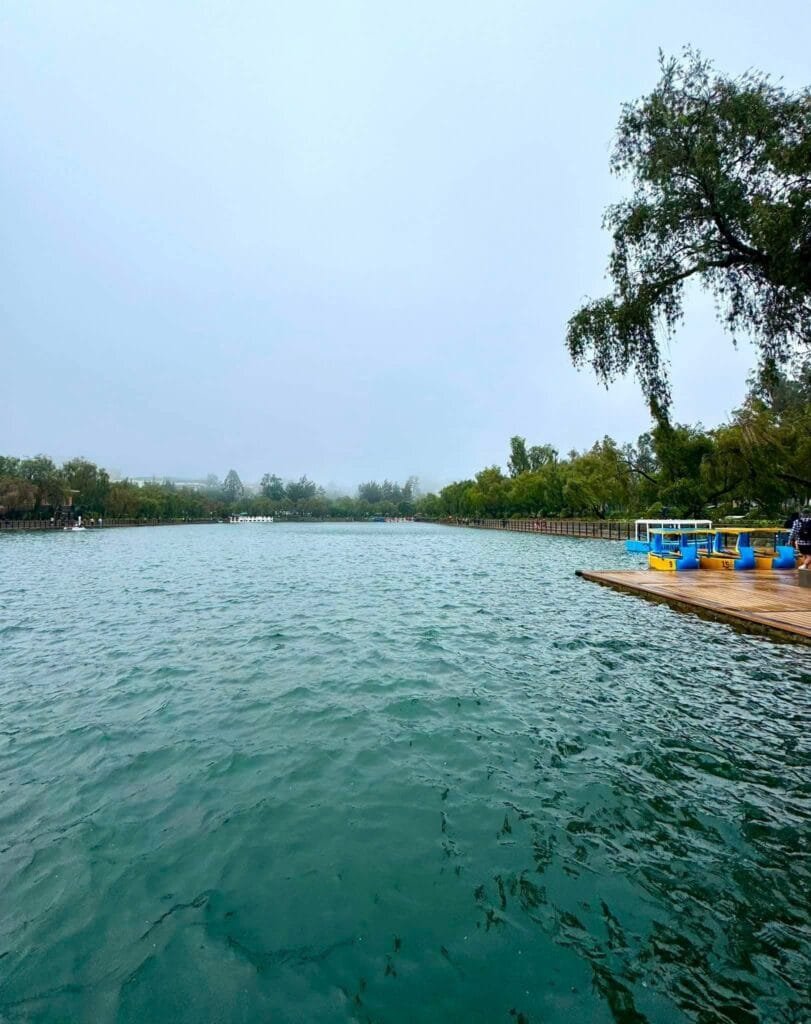 Burnham Park entrance and lakeside promenade with pine trees and open walkways in Baguio City