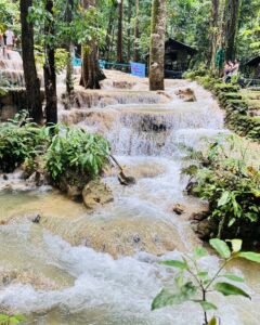 Aruyan Falls water terrace cascades flowing over stepped limestone rock into a wide jungle pool in Sablayan